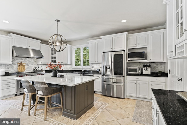 kitchen featuring stainless steel appliances, under cabinet range hood, white cabinets, decorative backsplash, and recessed lighting