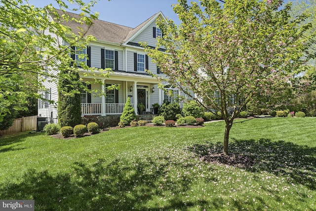 view of front of home with a porch, roof with shingles, and central AC