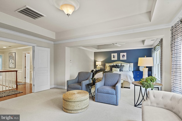 carpeted bedroom with crown molding, a tray ceiling, and baseboards