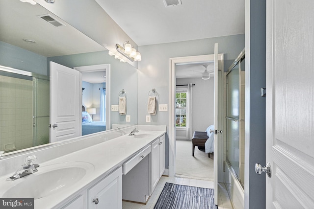 ensuite bathroom featuring double vanity, tile patterned flooring, baseboards, ceiling fan, and combined bath / shower with glass door