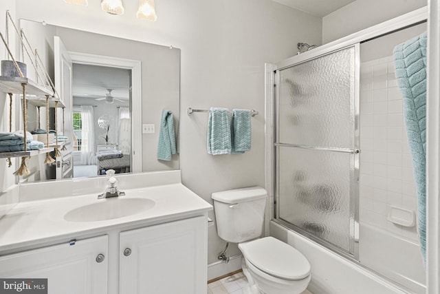 bathroom with connected bathroom, toilet, vanity, ceiling fan, and shower / bath combination with glass door