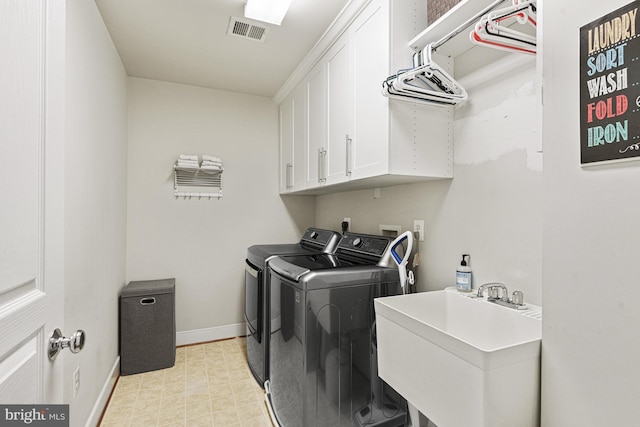 washroom featuring washing machine and clothes dryer, cabinet space, baseboards, and light flooring