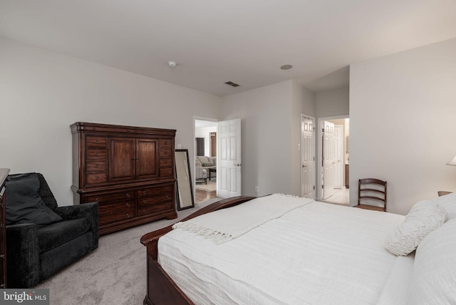 bedroom featuring light colored carpet and connected bathroom