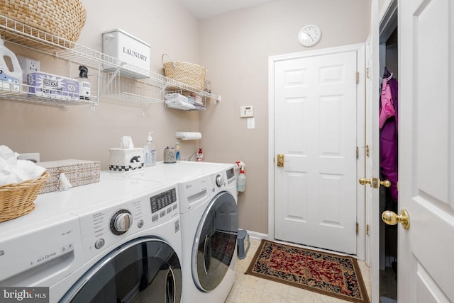 clothes washing area with independent washer and dryer and baseboards