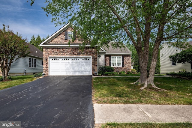 traditional-style house with stone siding, driveway, a front lawn, and an attached garage