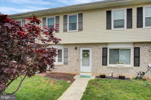 view of front of house with a front lawn and brick siding
