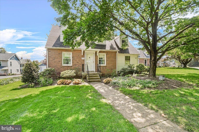 view of front facade featuring brick siding and a front lawn