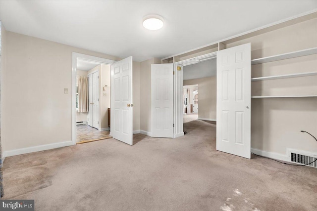 unfurnished bedroom featuring carpet floors, baseboards, a closet, and baseboard heating