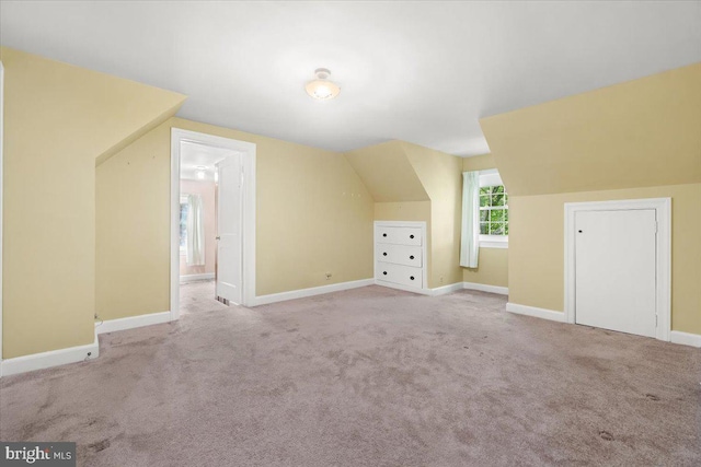 additional living space with lofted ceiling, baseboards, and carpet floors