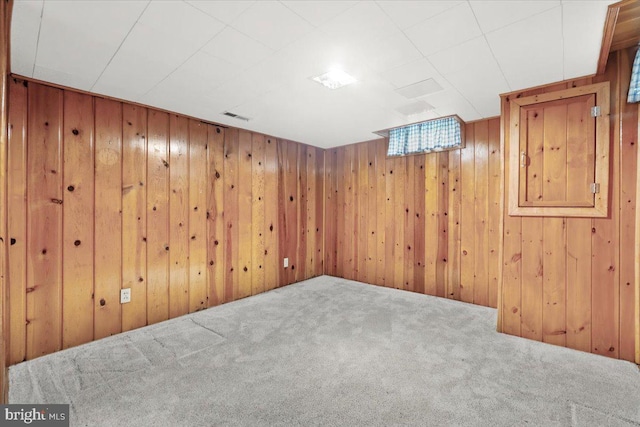 carpeted empty room with wood walls