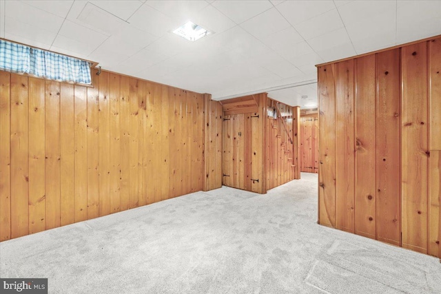 basement with carpet flooring and wood walls