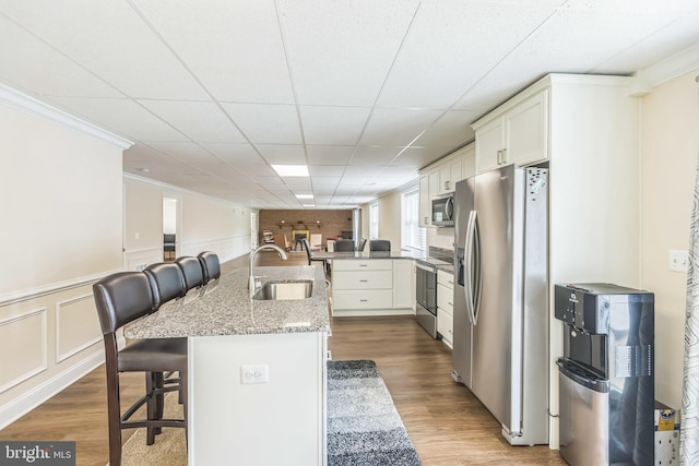 7290 Southern Maryland Blvd, Owings, MD 20736 - kitchen with appliances with stainless steel finishes, a sink, a kitchen breakfast bar, open floor plan, and white cabinetry