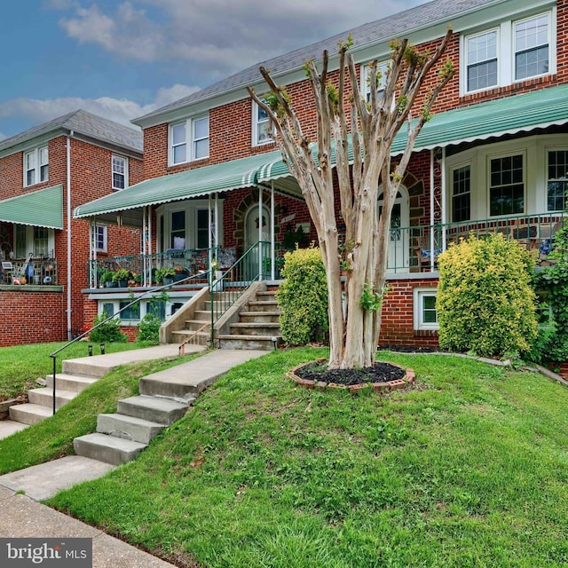 409 Academy Rd, Baltimore, MD 21228 - view of property with a porch, a front lawn, and brick siding