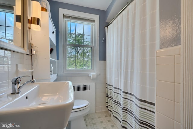 409 Academy Rd, Baltimore, MD 21228 - bathroom with tile walls, a sink, radiator, healthy amount of natural light, and toilet