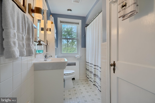 409 Academy Rd, Baltimore, MD 21228 - bathroom with tile walls, toilet, radiator, vanity, and tile patterned floors