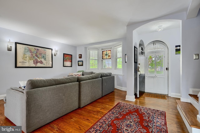 409 Academy Rd, Baltimore, MD 21228 - living room featuring arched walkways, wood finished floors, healthy amount of natural light, and baseboards