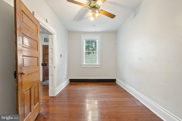 unfurnished room with hardwood / wood-style floors, baseboards, baseboard heating, and a ceiling fan