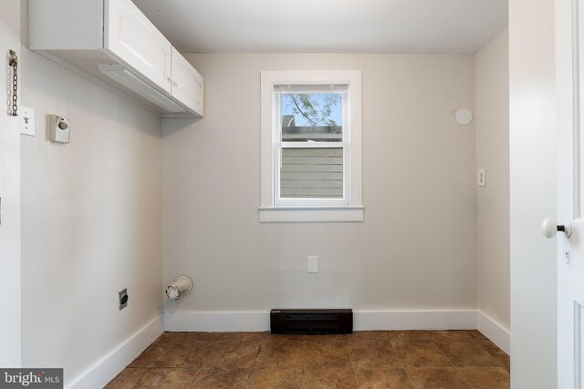 laundry room with hookup for an electric dryer, cabinet space, and baseboards