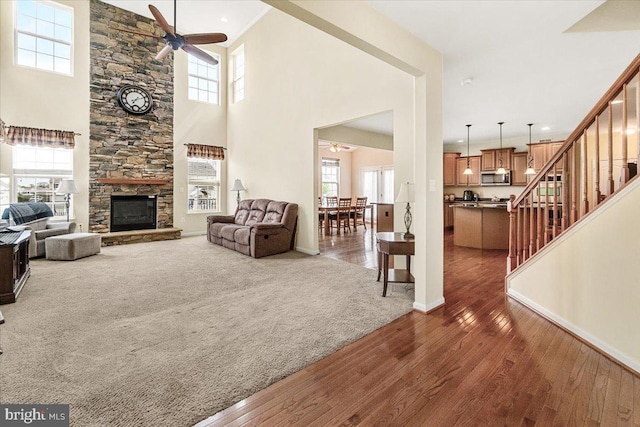 13324 John Martin Dr, Williamsport, MD 21795 - living area with a ceiling fan, a fireplace, hardwood / wood-style floors, baseboards, and stairs