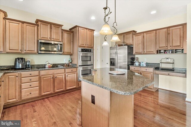 13324 John Martin Dr, Williamsport, MD 21795 - kitchen featuring light wood finished floors, a center island, dark stone counters, and appliances with stainless steel finishes
