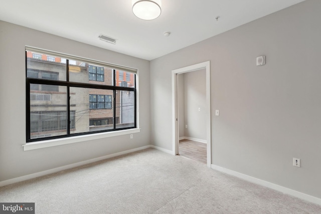 carpeted empty room with baseboards and fire sprinkler in ceiling