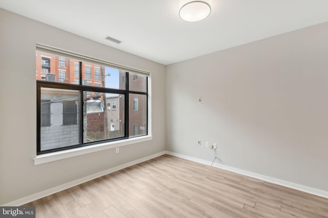 empty room featuring wood finished floors and baseboards