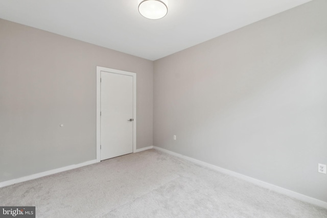 carpeted spare room featuring baseboards