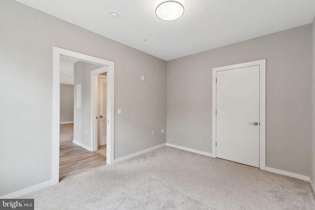 carpeted empty room featuring baseboards and a smoke detector