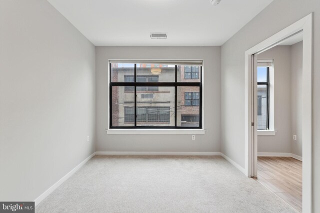 unfurnished room featuring carpet and baseboards