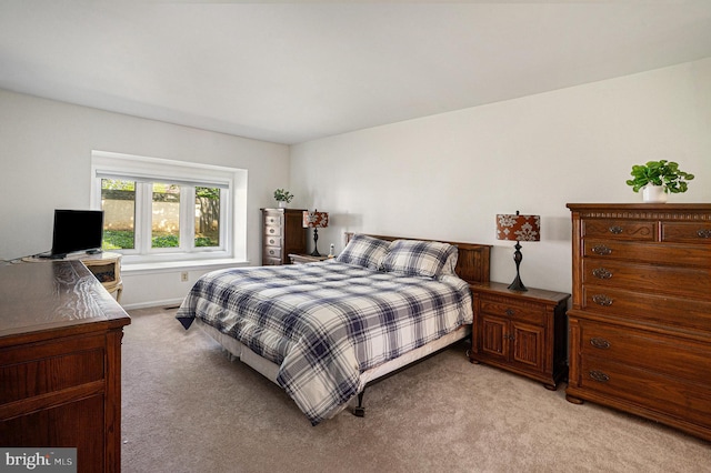 bedroom with light carpet and baseboards