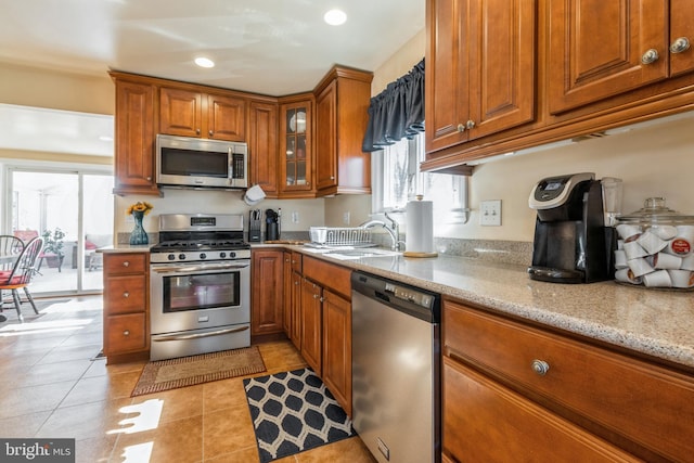 22 N Browning Ave, Somerdale, NJ 08083 - kitchen featuring stainless steel appliances, brown cabinetry, a sink, light stone counters, and light tile patterned floors