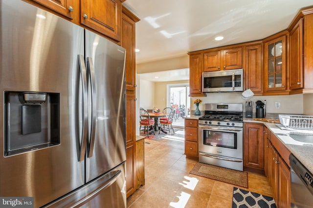 22 N Browning Ave, Somerdale, NJ 08083 - kitchen with stainless steel appliances, brown cabinetry, light tile patterned flooring, glass insert cabinets, and recessed lighting