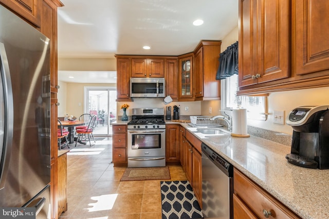 22 N Browning Ave, Somerdale, NJ 08083 - kitchen featuring stainless steel appliances, a sink, brown cabinets, light tile patterned floors, and light stone countertops