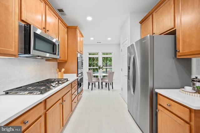 kitchen featuring appliances with stainless steel finishes, recessed lighting, light countertops, and backsplash