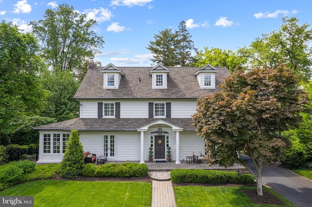 view of front of house with a front yard and a chimney