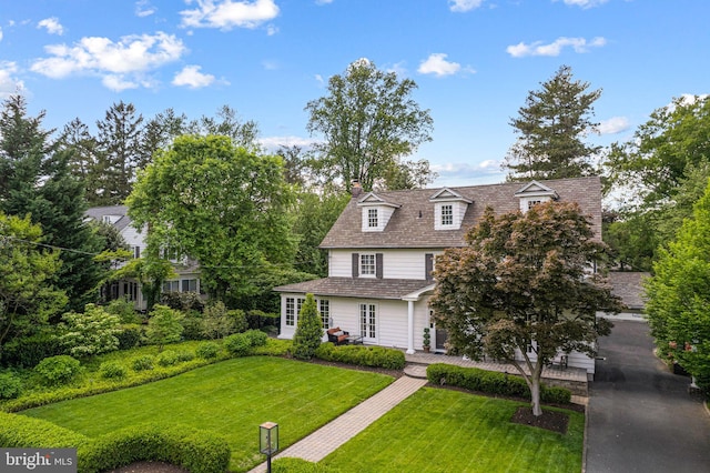 view of front of home with a front lawn, a chimney, and french doors