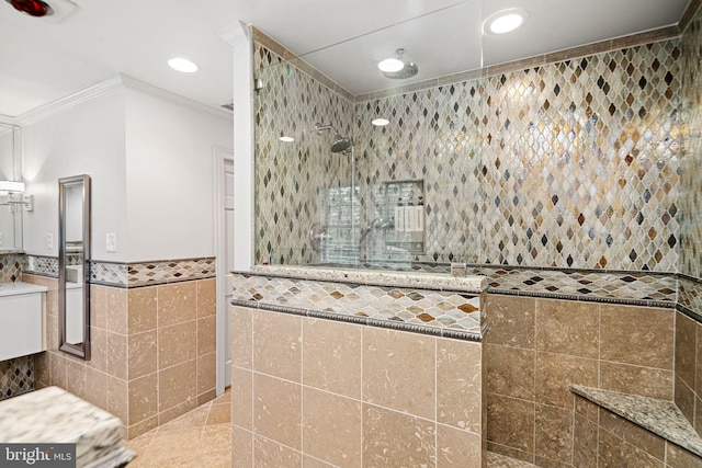 full bath featuring tile walls, crown molding, walk in shower, recessed lighting, and wainscoting