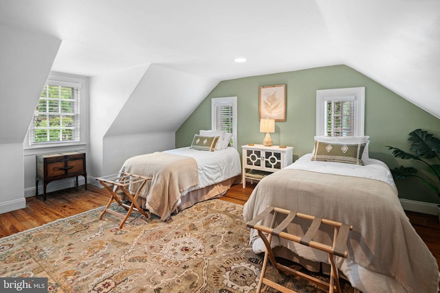 bedroom with lofted ceiling, wood finished floors, and baseboards