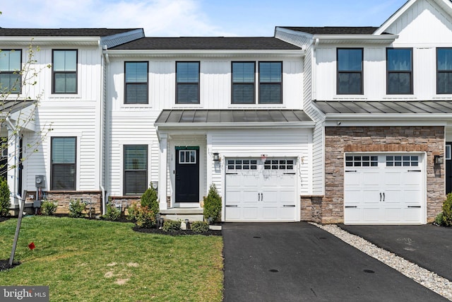 multi unit property with aphalt driveway, an attached garage, a standing seam roof, and stone siding