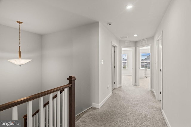 corridor featuring visible vents, an upstairs landing, recessed lighting, carpet flooring, and baseboards