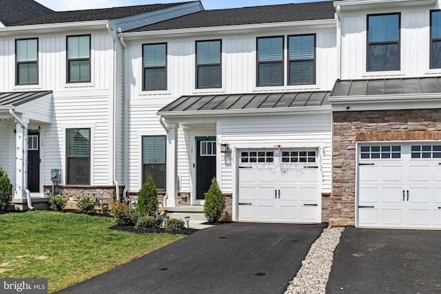 multi unit property with driveway, a standing seam roof, a garage, stone siding, and a front lawn