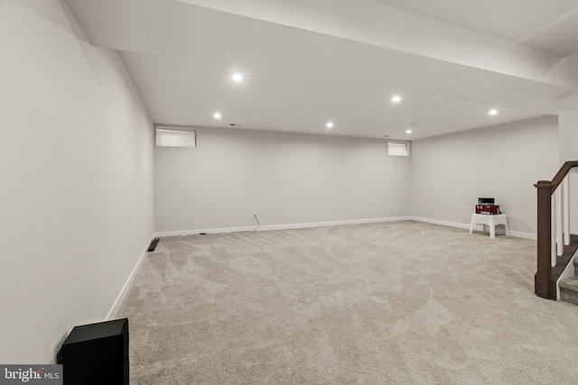 finished basement featuring stairway, light colored carpet, baseboards, and recessed lighting