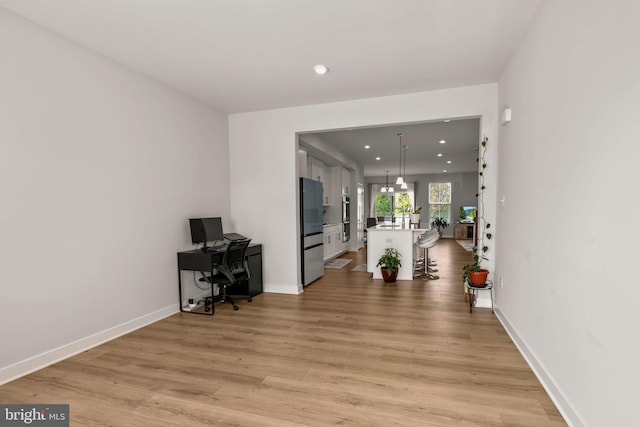 office space featuring baseboards, light wood-type flooring, and recessed lighting
