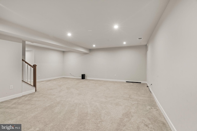 finished basement with stairway, light carpet, baseboards, and recessed lighting