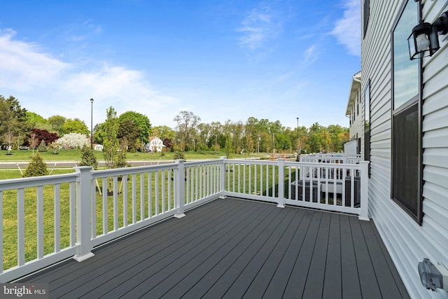 wooden terrace featuring a lawn