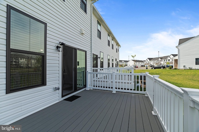 wooden deck featuring a yard and a residential view