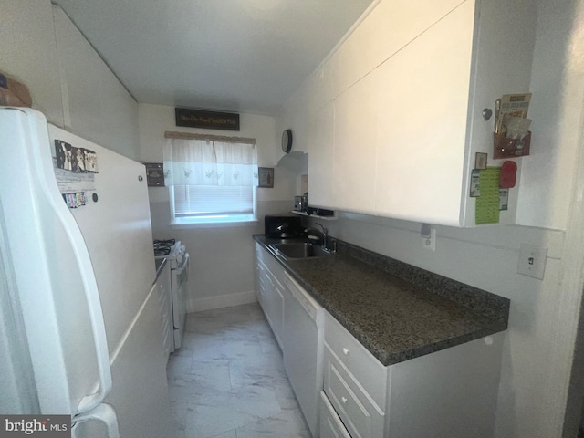 kitchen with white appliances, a sink, light marble finish flooring, dark countertops, and white cabinets