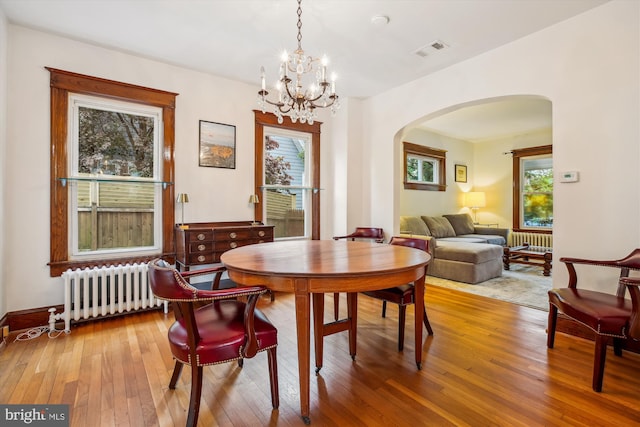 4311 Ellicott St NW, Washington, DC 20016 - dining room with radiator heating unit, arched walkways, and healthy amount of natural light