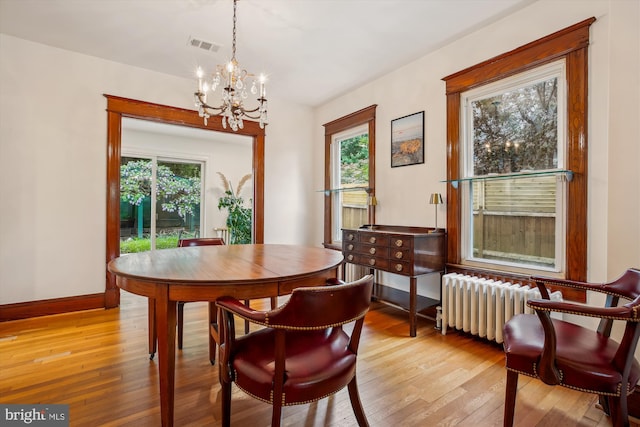 4311 Ellicott St NW, Washington, DC 20016 - dining space with radiator, a chandelier, healthy amount of natural light, and light wood-type flooring
