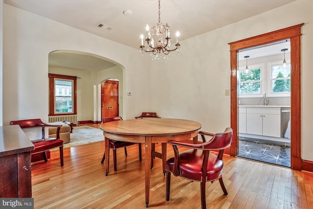 4311 Ellicott St NW, Washington, DC 20016 - dining room with light wood-style floors, arched walkways, plenty of natural light, and a chandelier